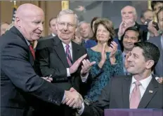  ?? Andrew Harnik/Associated Press ?? Speaker of the House Paul Ryan, R-Wis., right, shakes hands with House Ways and Means Committee Chairman Kevin Brady, R-Texas, as Senate Majority Leader Mitch McConnell, R-Ky., watches on Thursday in Washington.