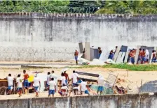  ??  ?? Internos de grupos rivales construyen barricadas dentro de la prisión de Alcacuz, donde ayer se registraro­n nuevos distrubios.