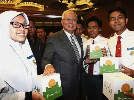  ??  ?? in Kuala Lumpur. Najib having a light moment with some students after launching the Akaun Remaja scheme Starting them young: