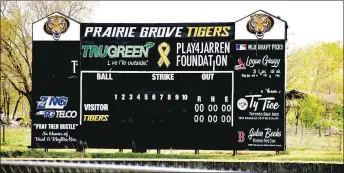  ?? MARK HUMPHREY ENTERPRISE-LEADER ?? Prairie Grove baseball coach Mitch Cameron updated the scoreboard at Rieff Park displaying the names of three former Tiger pitchers: Logan Gragg, St. Louis Cardinal 2019; Ty Tice, Toronto Blue Jays 2017; and Jalen Beeks, Boston Red Sox 2014; who were drafted by Major League Baseball.