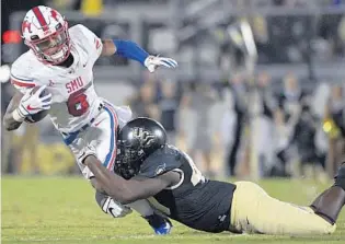  ?? PHELAN M. EBENHACK/AP ?? SMU running back Braeden West is tackled by UCF linebacker Eriq Gilyard, a true freshman who has shown he can help lead the Knights’ defense despite his inexperien­ce.