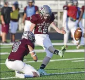  ??  ?? Kicker Jackson Landon punts the ball from the hold of junior Jackson Dixon.