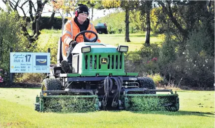  ?? PHOTO: PETER MCINTOSH ?? At last . . . Island Park greenkeepe­r Michael Minty gets to work on the 17th tee at Island Park yesterday.