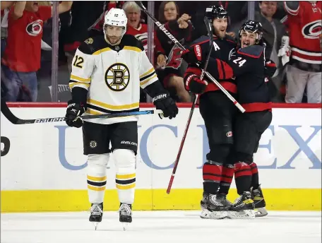  ?? AP ?? DRAB FIVE: Carolina’s Jaccob Slavin, center, celebrates his goal with teammate Seth Jarvis as Craig Smith skates past during the first period of Game 5 of their first-round playoff series in Raleigh, N.C., on Tuesday night.