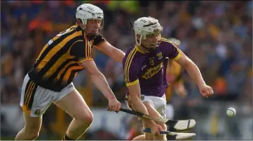  ??  ?? Wexford attacker Cathal Dunbar under pressure from Kilkenny’s Michael Cody in Wednesday’s final.