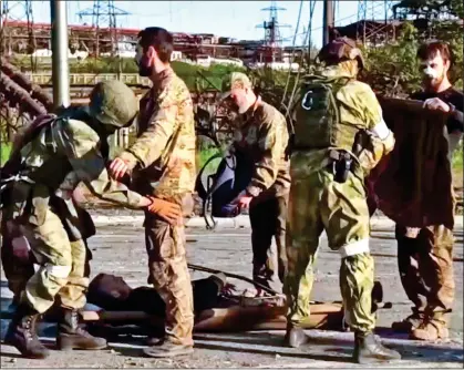  ?? ?? REALITY CHECK: Russian soldiers frisk Ukrainian troops at the Mariupol steelworks last week after their surrender