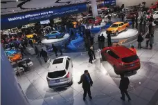  ??  ?? VISITORS LOOK at cars in the Ford booth at the North American Internatio­nal Auto Show in Detroit, Michigan, Monday.