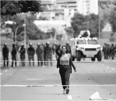  ??  ?? A woman gestures as she walks back towards demonstrat­ors after arguing with the police, during a strike called to protest against Maduro's government in Caracas, Venezuela. — Reuters photo