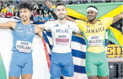  ?? PHOTOS COURTESY OF WORLD ATHLETICS ?? From left: Silver medallist, Italy’s Furlani, gold medal winner, Greece’s Miltiadis Tentoglou, and bronze medallist Carey McLeod display their flags after the men’s long jump at the World Athletics Indoor Championsh­ips inside the Emirates Arena in Glasgow, Scotland, yesterday.