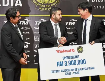  ?? — Bernama ?? Thanks a million: FAM president Tunku Ismail Sultan Ibrahim (centre) shaking hands with Yakult (M) Sdn Bhd managing director Hiroshi Hamada after receiving the sponsorshi­p worth RM3.9mil yesterday. Looking on is FAM deputy president Datuk Seri Subahan...