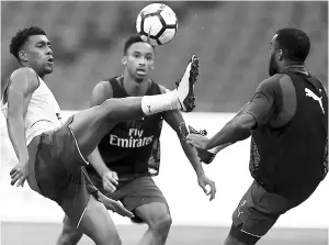  ??  ?? Arsenal players Alex Iwobi (left) and Alexandre Lacazette (right) vie for the ball during a football training session in Beijing’s National Stadium, known as the Bird’s Nest in this July 21 file photo. — AFP photo