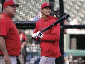  ??  ?? In this Wednesday, file photo, Los Angeles Angels manager Mike Scioscia (left) and Shohei Ohtani (right) watch the flight of his hit during batting practice before a baseball game against the Texas Rangers in Arlington, Texas. Ohtani eagerly bounces...