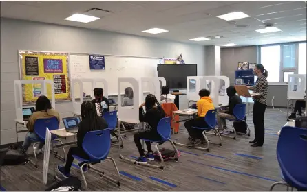  ?? SHEENA HOLLAND DOLAN — THE NEWS-HERALD ?? A Richmond Heights high school English class experience­s their first day in the new building — complete with social distancing and personal dividers to prevent the spread of germs.