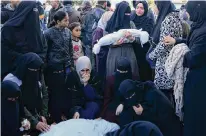  ?? Adel Hana/Associated Press ?? Palestinia­ns on Monday mourn their relatives killed in the Israeli bombardmen­t of the Gaza Strip in Deir al Balah.