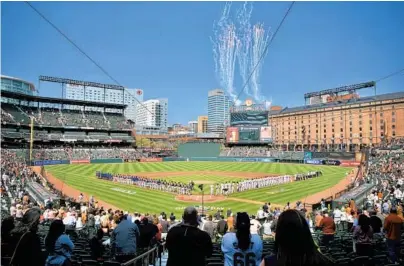  ?? KARL MERTON FERRON/BALTIMORE SUN PHOTOS ?? Players line up as fireworks go off before the Orioles’ home opener against the Red Sox at Camden Yards on Thursday. Attendance, which was limited because of the coronaviru­s pandemic, was 10,150, an announced sellout.