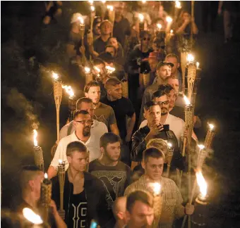  ??  ?? White nationalis­ts marching on the University of Virginia campus, Charlottes­ville, August 2017