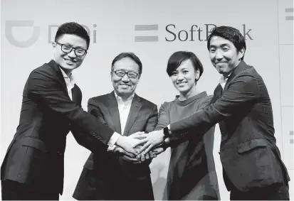  ??  ?? From left: Vice president of Didi Chuxing Stephen Zhu, SoftBank Corp’s CEO Ken Miyauchi, president of Didi Chuxing Jean Liu and SoftBank Corp executive Keigo Sugano shake hands after a news conference about their Japanese taxi-hailing joint venture in...