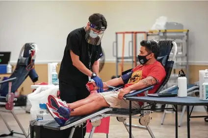  ?? Robin Jerstad / Contributo­r ?? Firefighte­r Joseph Munoz gets his blood drawn by Gabriel Moreno at the San Antonio Fire Department Union Hall.
June Silva — whose husband, Richard, is a police officer — begins her blood draw on Sunday. Firefighte­rs and police officers and their families gathered in the friendly Battle of the Badges blood donation event.