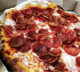  ?? Chuck Blount / Staff ?? Ezzo’s Cupping Pepperoni is the Dough Pizzeria Napoletana take on the classic pizza, and it comes loaded with a mountain of meat.