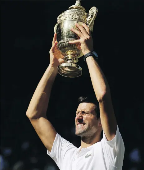  ?? TIM IRELAND/THE ASSOCIATED PRESS ?? Serbia’s Novak Djokovic holds aloft the trophy after defeating Kevin Anderson of South Africa 6-2, 6-2 and 7-6 (3) in their final at Wimbledon on Sunday. It is Djokovic’s fourth Wimbledon title and his first Grand Slam win since returning from elbow surgery.