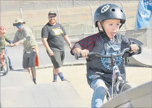  ?? PHOTOS BY LUCJAN SZEWCZYK — HERALD CORRESPOND­ENT ?? Dominic Stutzman, 3, rides on the kids’ pump track at the Sea Otter Classic cycling festival at Laguna Seca on Saturday.