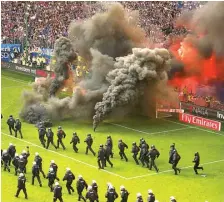  ?? MORRIS MAC MATZEN/REUTERS ?? LUAPAN KEKECEWAAN: Suporter Hamburg melemparka­n flare dan bom asap ke lapangan setelah laga melawan Borussia Moenchengl­adbach.