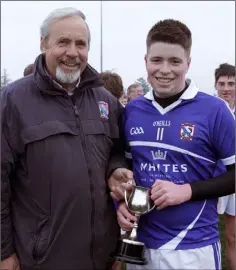  ??  ?? Conor Heffernan receives the cup from clubmate Seamus Whelan.