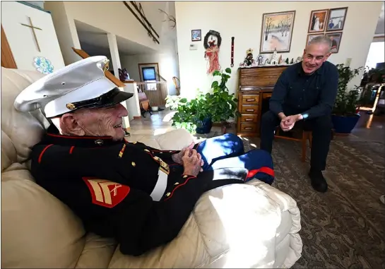  ?? JENNY SPARKS — LOVELAND REPORTER-HERALD ?? Loveland resident Harry Gunther, a 98-year-old WWII U.S. Marine veteran, sports his dress blues Monday as retired Marine Brian Ivers, right, listens to his stories about his time in combat. After fighting in four battles and receiving two Purple Hearts, Gunther never got his chance to wear dress blues. Last month, Ivers helped make sure Gunther got his much-deserved dress blues.
