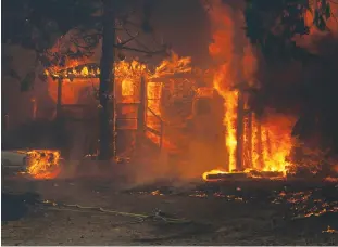  ?? Tribune News Service/getty Images ?? A home burns on Highway 89 south of Greenville near Forgay Road during the Dixie fire on Aug. 5, 2021.