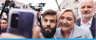  ?? — AFP ?? SAINT-PIE E-EN-AUGE France: French far-right assembleme­nt National N party Member of Parliament and presidenti­al candidate Marine Le Pen C poses for photos with members of the public during a campaign isit to Saint-Pierreen-Auge northweste­rn France on April .