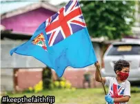  ?? Photo: Leon Lord ?? Sovaia Gauna, 6, waved the Fiji flag in solidarity at Tamavua, as the Suva-Nausori containmen­t zones went into lockdown on Friday, May 14, 2021.