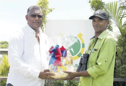  ?? (Photos: Naphtali Junior) ?? On Saturday, September 11, Patrol Judge Kirk Kong (right) receives a gift basket for his services to the racing industry from Denzil Millier, racing secretary.