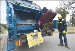  ?? (NWA Democrat-Gazette/e/Hank Layton) ?? Equipment operator Zac Dwyer loads waste Friday into a garbage truck driven by Roman Williams in a residentia­l neighborho­od in south Fort Smith. The city’s Board of Directors is preparing to approve annual budgets, which may include several new trucks for the Solid Waste Department. Go to nwaonline.com/211031Dail­y/ to see more photos.