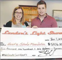 ?? HEATHER TAWEEL/THE GUARDIAN ?? Crystal Cobb, left, Heart and Stroke Foundation, accepts a donation from Landon Holmes. Funds for the donation came from Landon’s light show, an annual Christmas display in Stratford consisting of 30,000 lights.