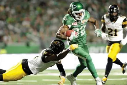  ?? MARK TAYLOR, THE CANADIAN PRESS ?? Roughrider­s’ Naaman Roosevelt (82) shakes a tackle during second-half action against the Ticats in Regina on Saturday. The Riders beat the Ticats, 37-20.