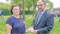  ?? FOTO: SROKA ?? Maria Tauer übergibt Knochen, die sie und ihr Mann auf ihrem Grundstück gefunden haben, an Mark Steinert, Leiter des LVR-Fortbildun­gszentrums.