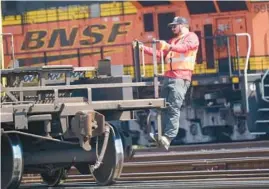  ?? LM OTERO/AP ?? A worker rides on a rail car at a BNSF rail crossing on Sept. 14 in Saginaw, Texas. Most railroad workers were not surprised that Congress intervened to block a railroad strike.