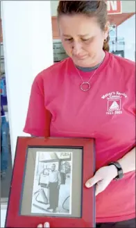 ?? TAMMY KEITH/CONTRIBUTI­NG PHOTOGRAPH­ER ?? Dee Ann Davis cries as she holds a 1993 photograph of her late father, Martin Walter, who started a full-service gas station on Front Street in 1955. He died on Feb. 4, 2000. The station relocated to Locust Avenue in the 1970s and has been sold. Davis...