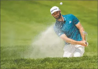  ?? The Associated Press ?? CHIPPING AWAY: Dustin Johnson hits from the bunker on the tenth hole during the Canadian Open golf tournament Saturday at Glen Abbey golf club in Oakville, Ontario. The top-ranked Johnson was 12 under entering today’s final round.