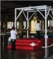  ??  ?? A gold leaf is added to a bell in the Wat Dhammakaya, a temple which radiates wealth in Thailand.