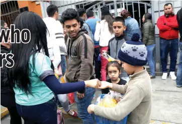  ??  ?? A Venezuelan migrant child sells food outside their embassy while others wait to register for a flight to return to their country, in Lima, Peru Sept 5. — Reuters photo