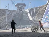  ?? PHOTO: AFP ?? People work at the constructi­on site of the ski jump arena of the 2022 Winter Olympics in Hebei province.
