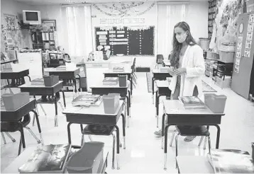  ?? OCTAVIO JONES/THE NEW YORK TIMES ?? Katie Stallings prepares her second-grade classroom at MacFarlane Park Elementary in Tampa. The state allowed just the three largest districts — in Miami-Dade, Broward and Palm Beach Counties — to remain virtual after Aug. 31.