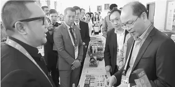  ??  ?? Madius (right) interactin­g with one of the Malaysian exhibitors at Malaysia Pavilion, Astana Expo 2017. Also present was Energy, Green Technology and Water deputy secretary-general Datuk Dr Tan Yew Chong (second right). — Bernama photo