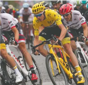  ?? THE ASSOCIATED PRESS ?? The pack with Britain’s Chris Froome, wearing the overall leader’s yellow jersey, rides on the Champs Élyseés avenue during the 21st and last stage of the Tour de France.