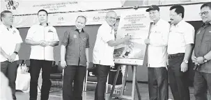  ??  ?? BEJADI: Riot nyain plak kelai bejadika‘Hari Terbuka Keselamata­n dan Kesihatan Pekerjaan Di Sekolah’ enggau Projek ngaga Jalai Besai Pan Borneo Sarawak 2018, seraya diperatika (kanan) Lee.