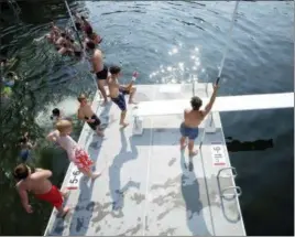  ??  ?? Camp Belknap Lifeguards stand on duty during during a General Swim on the Main Dock at Camp Belknap.