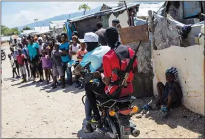  ?? (File Photo/ap/rodrigo Abd) ?? G9 coalition gang members ride a motorcycle Oct. 6 through the Wharf Jeremy street market in Port-au-prince, Haiti.