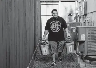  ?? Godofredo A. Vásquez / Staff photograph­er ?? Moonshot driver Cristian Flores collects compost while working his route. The startup offers to pick up food waste from homes and businesses and bring it to large-scale composting facilities.