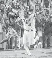  ?? Kevork Djansezian / Getty Images ?? Justin Turner of the Dodgers celebrates after hitting a three-run homer with two outs in the ninth. Turner also drove in the Dodgers’ first run and was 2-for-4.